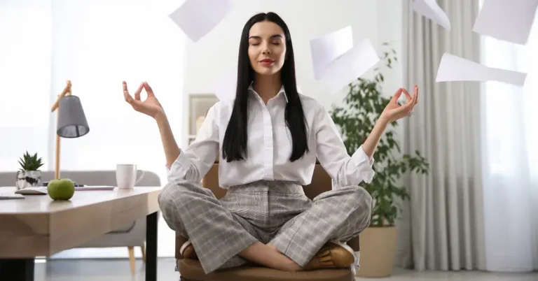 Meditation For Stress Relief At Work: For A Calmer Day 2024 8 Meditation for Stress Relief at Work: a woman is sitting in the office and meditate on her chair.